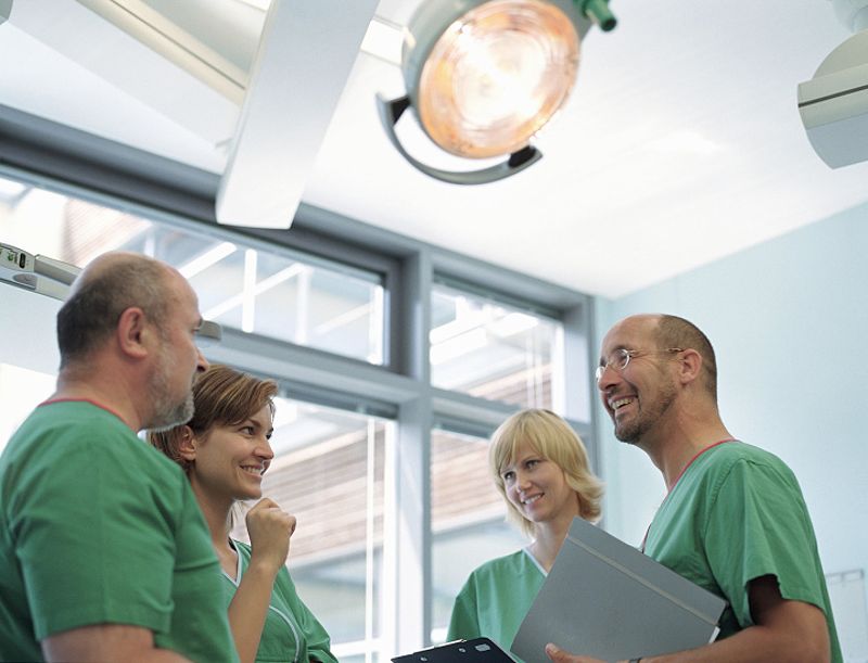 Medical professionals in scrubs discussing cases